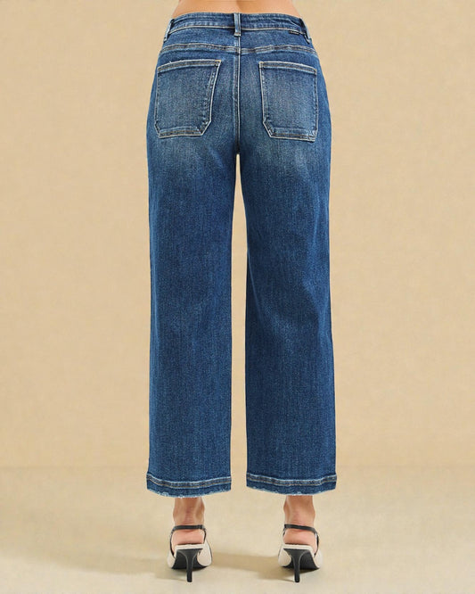 Blue jeans worn by a person on a beige background
