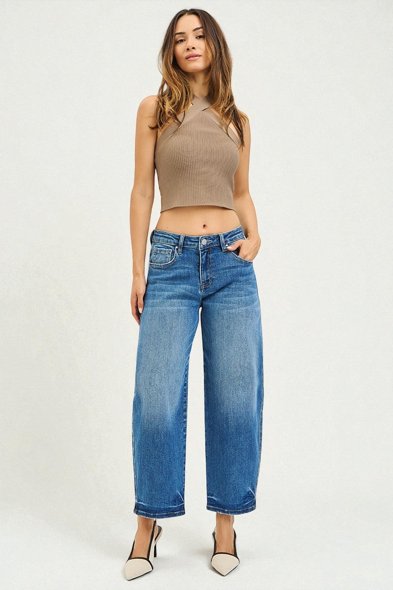 Woman wearing a brown halter top and blue jeans on a white background