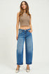 Woman wearing a brown halter top and blue jeans on a white background