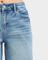 Close-up of blue jeans with rhinestone embellishments on a light gray background