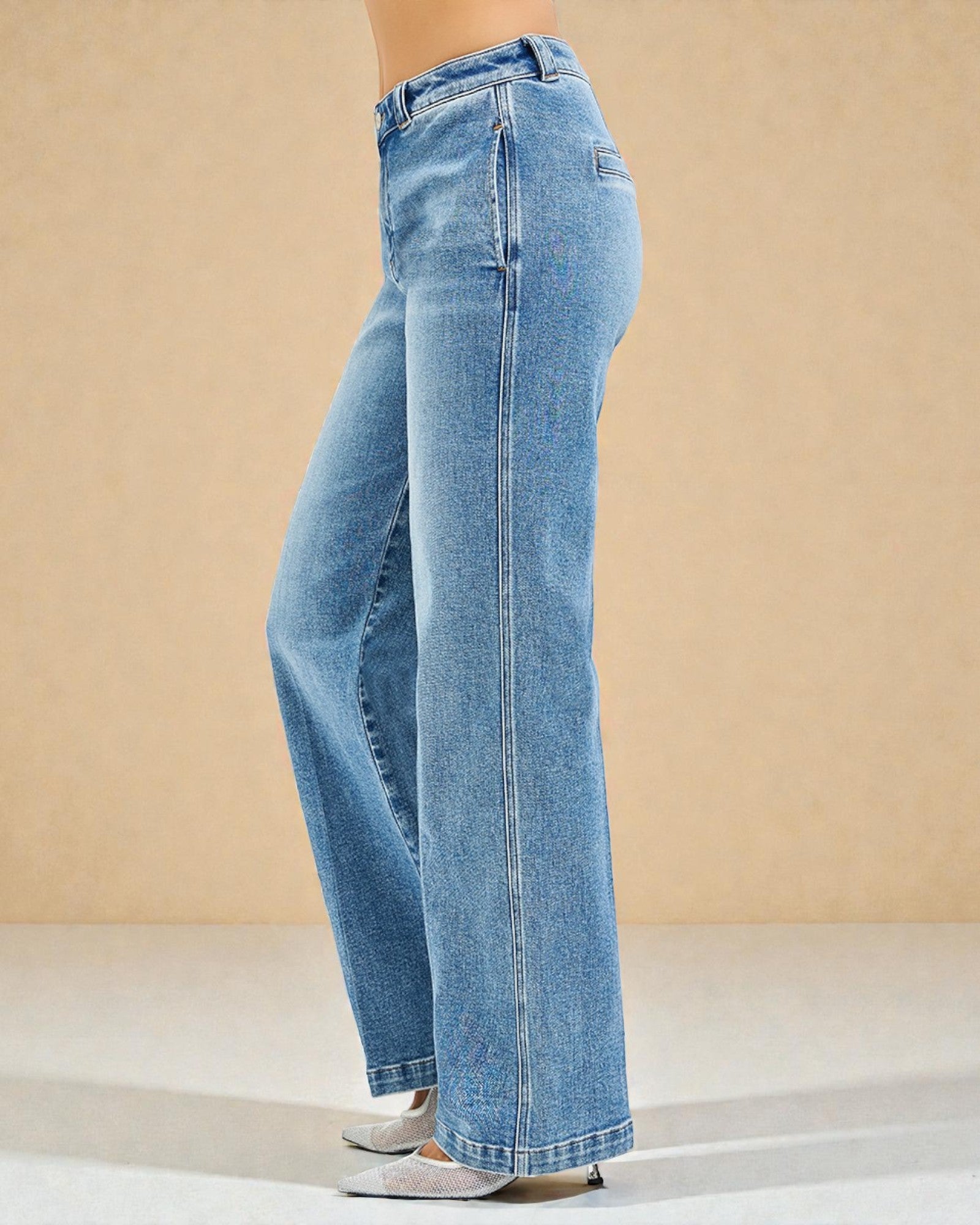 Blue jeans worn by a person on a beige background