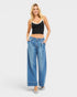 Woman wearing blue jeans and a black tank top on a white background