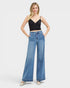 Woman wearing blue jeans and a black top on a white background