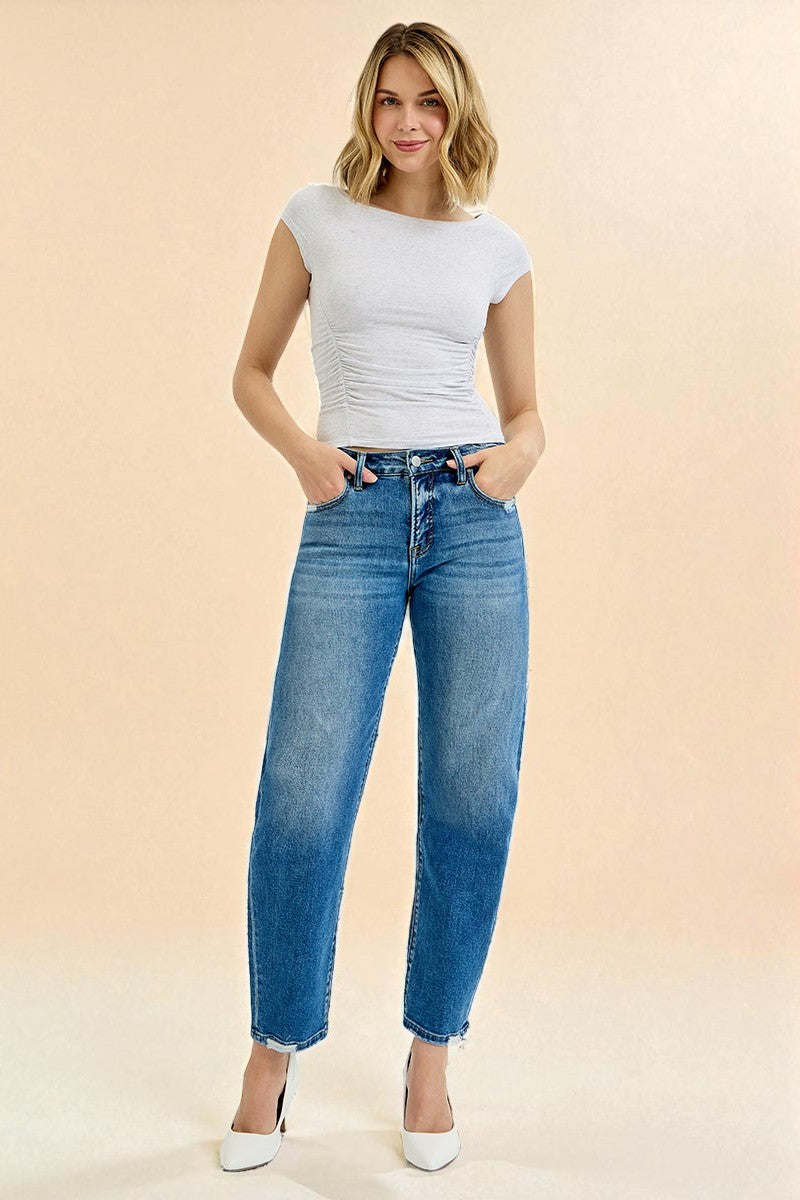 Woman wearing a white top and blue jeans on a beige background