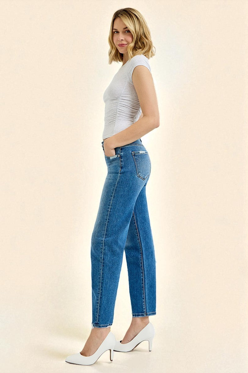 Woman wearing blue jeans and a white top on a beige background