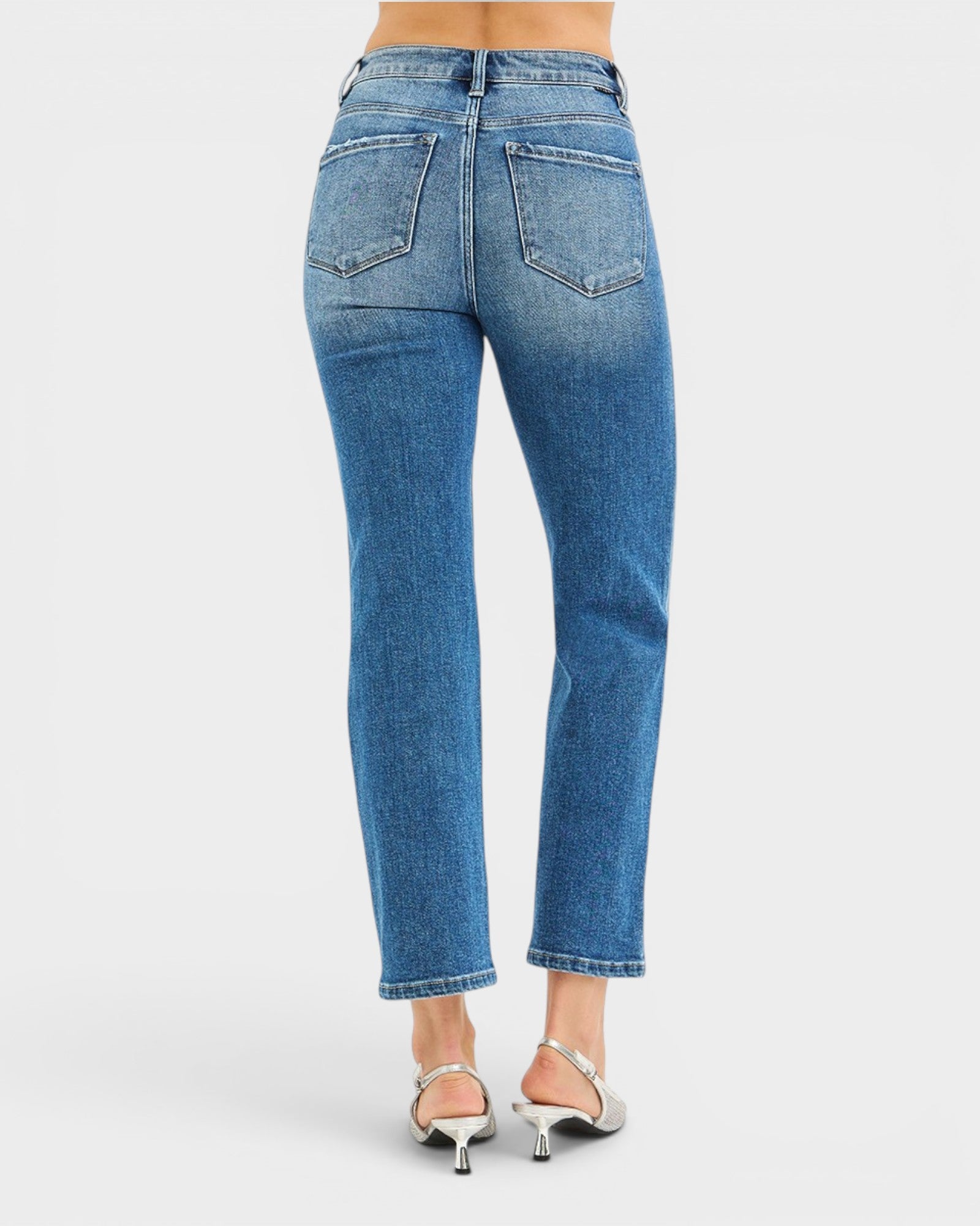 Blue jeans worn by a person on a white background