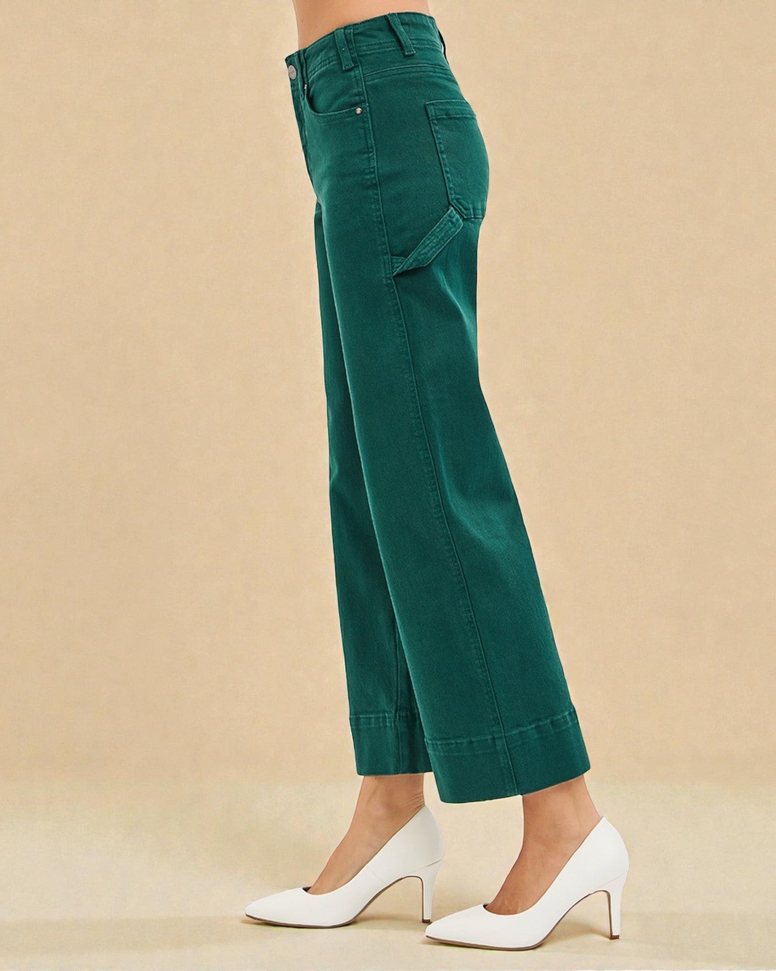 Green pants worn by a person on a beige background