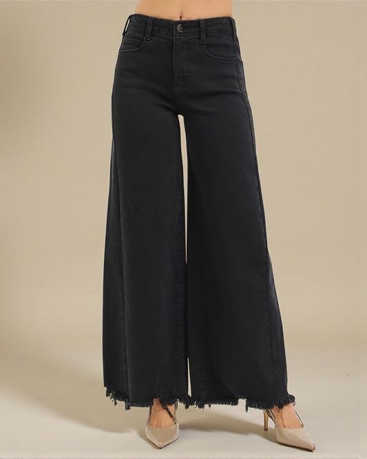 Black wide-leg jeans on a beige background