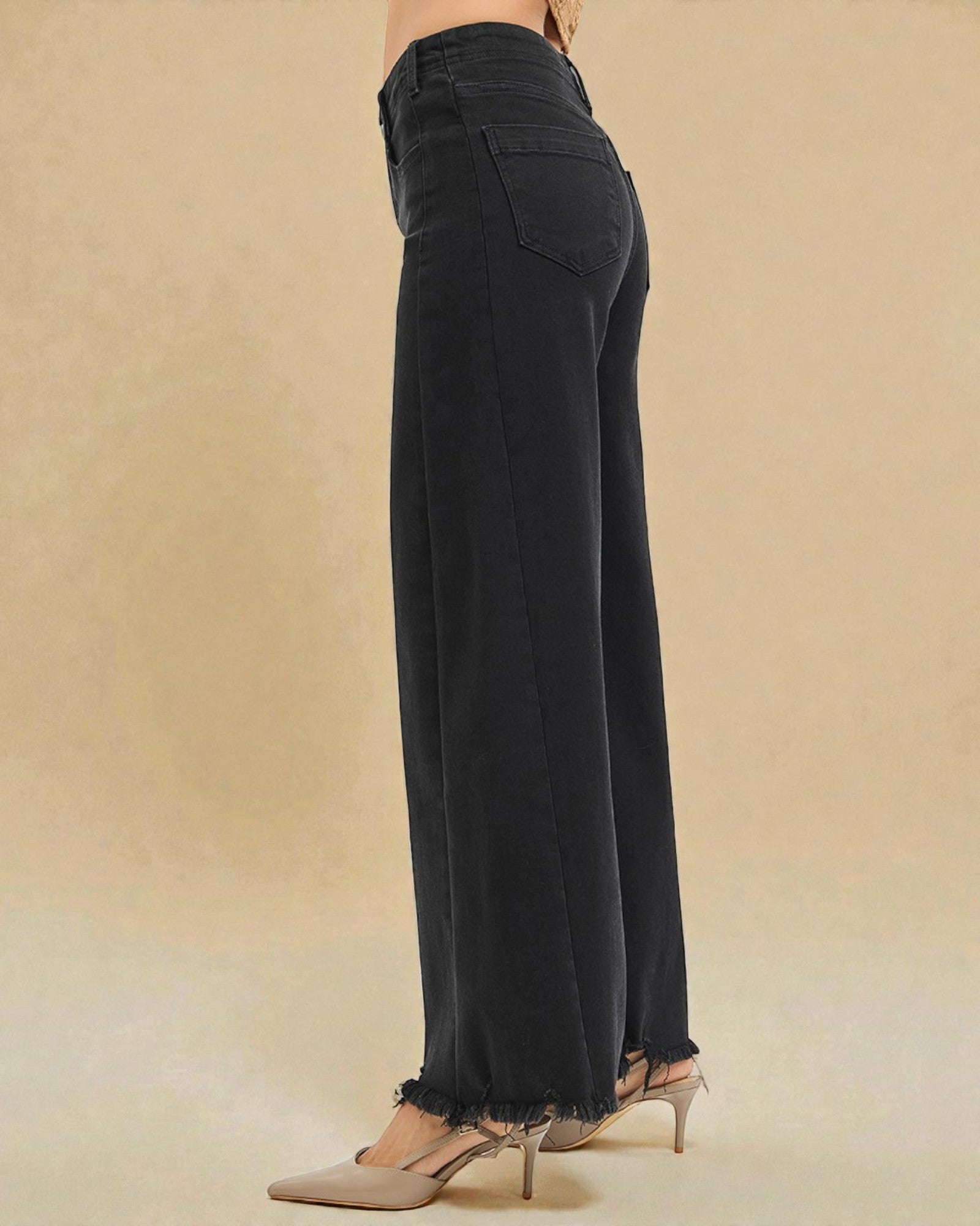 Black wide-leg pants worn by a person on a beige background