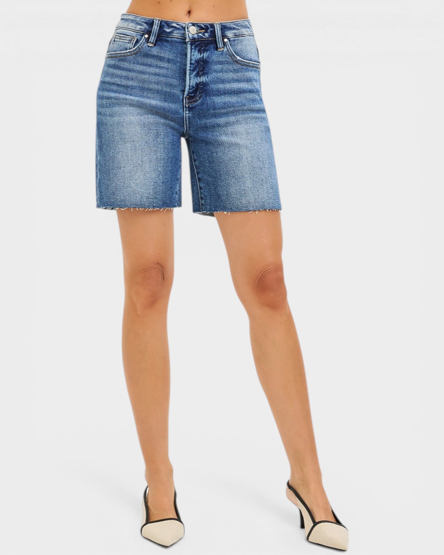 Blue denim shorts worn by a person on a white background