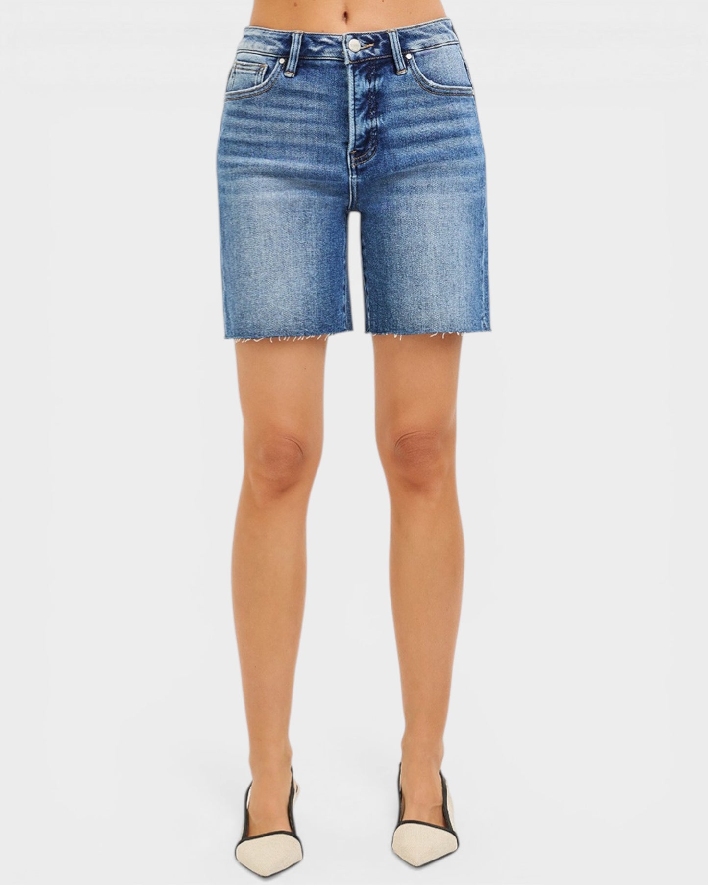 Denim shorts worn by a person on a white background