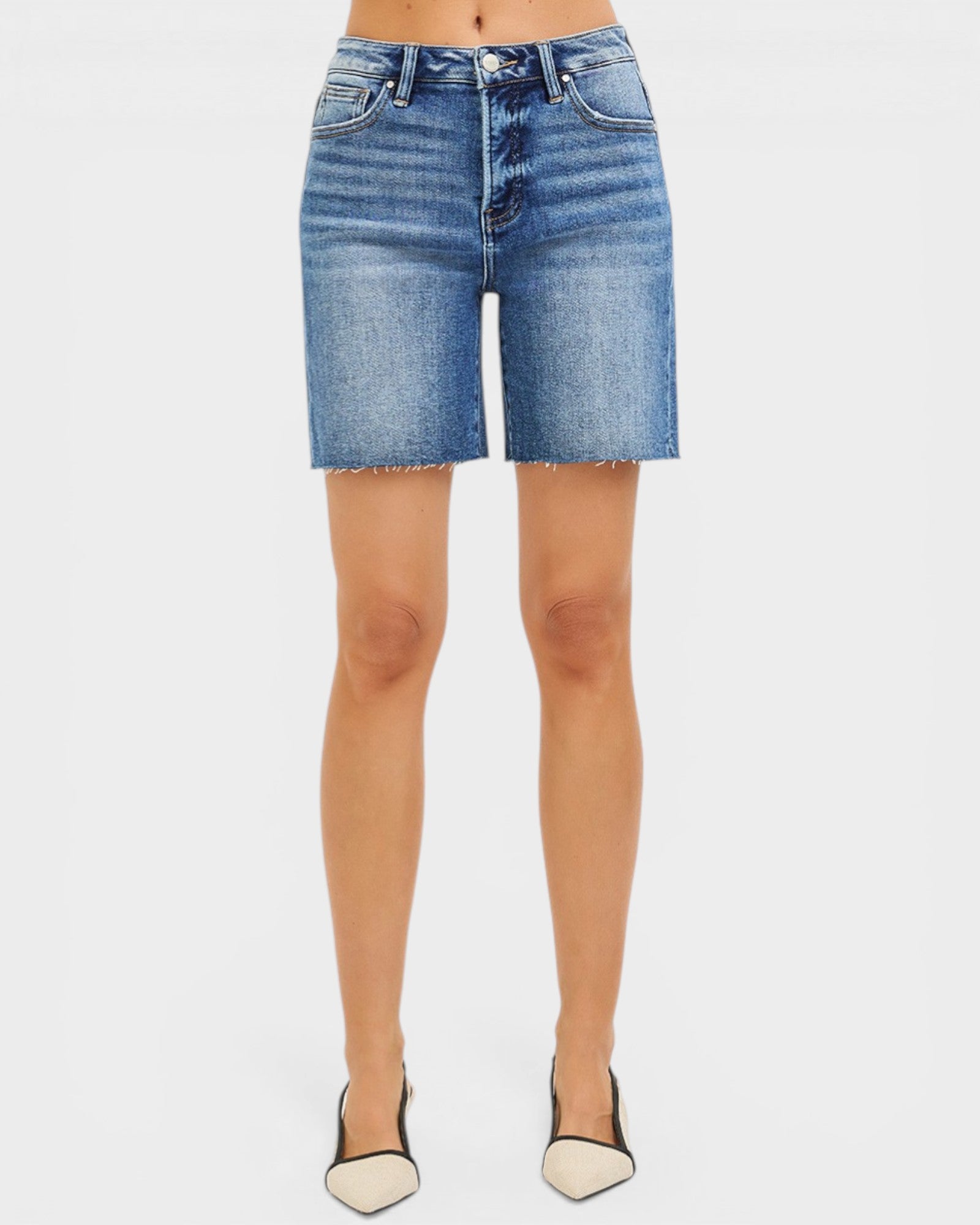 Denim shorts worn by a person on a white background