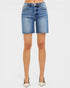Denim shorts worn by a person on a white background