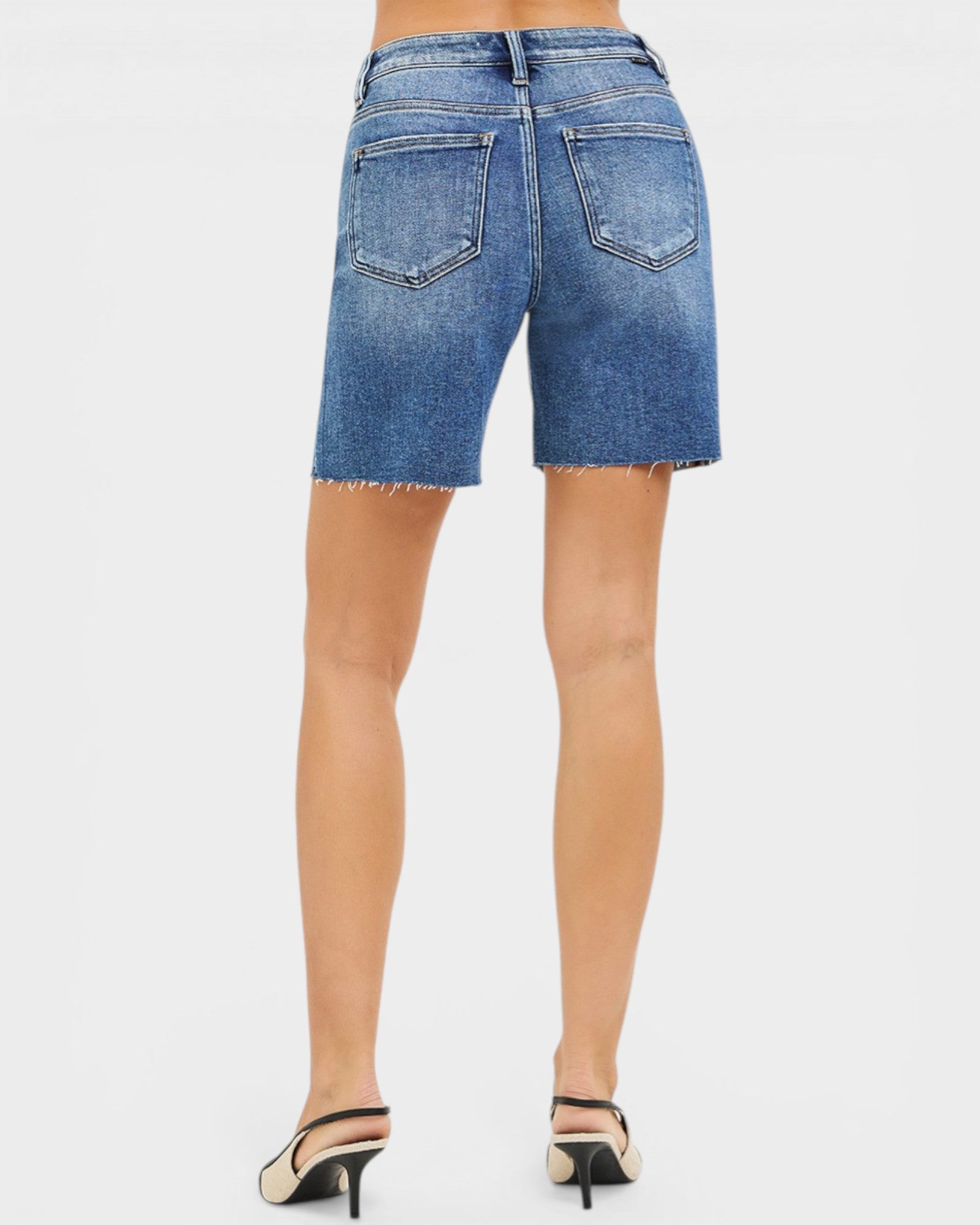 Blue denim shorts worn by a person on a white background