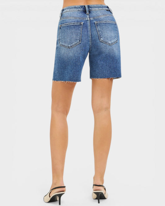 Blue denim shorts worn by a person on a white background