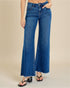 Blue jeans worn by a person on a beige background