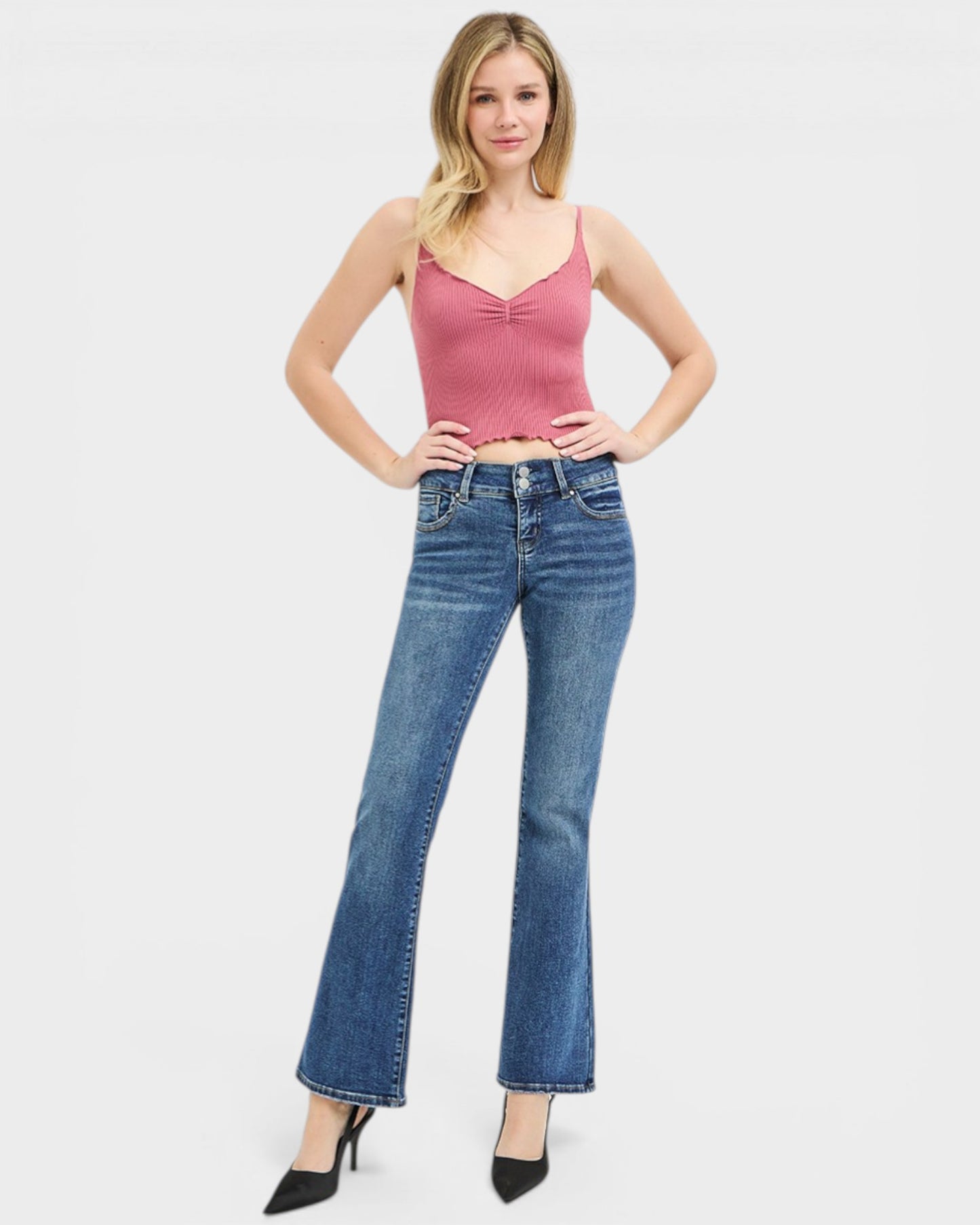 Woman wearing a pink top and blue jeans on a white background