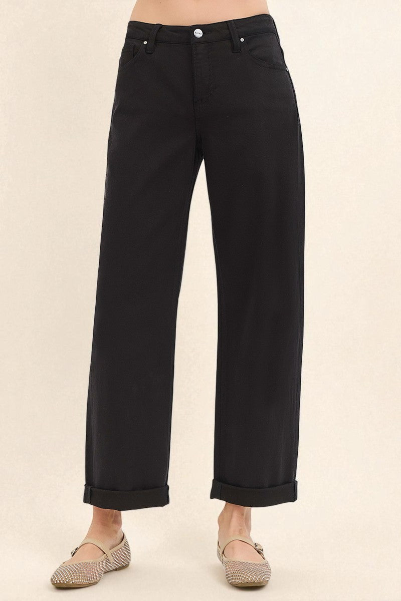 Black pants worn by a person on a beige background
