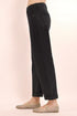 Black pants worn by a person on a light pink background