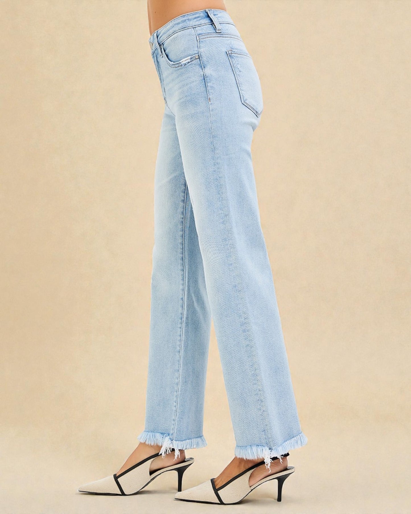 Light blue jeans worn by a person on a beige background