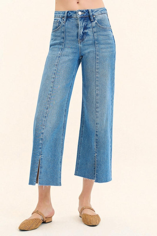 Blue jeans worn by a person on a beige background