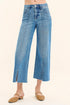 Blue jeans worn by a person on a beige background