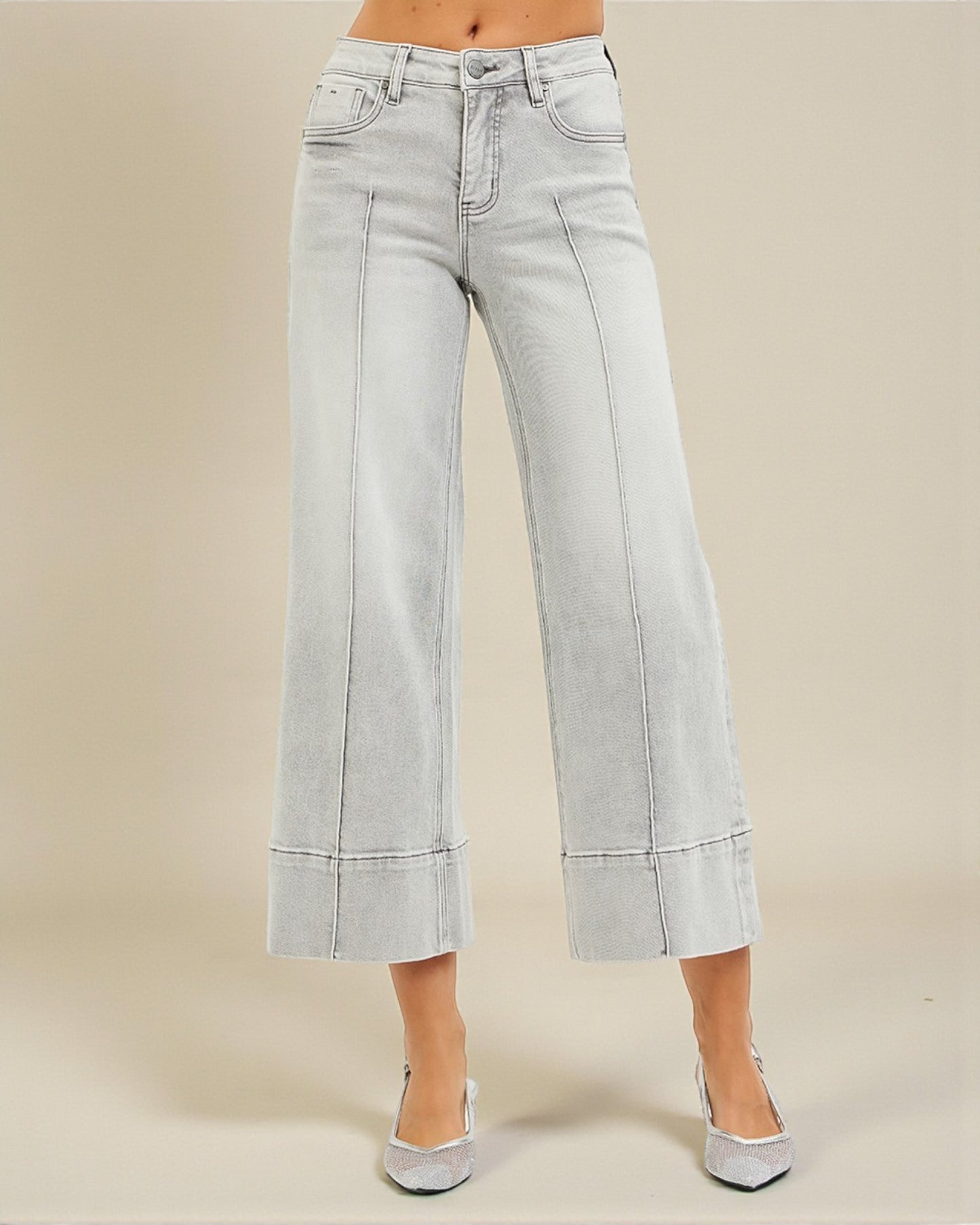 Light blue jeans worn by a person on a beige background