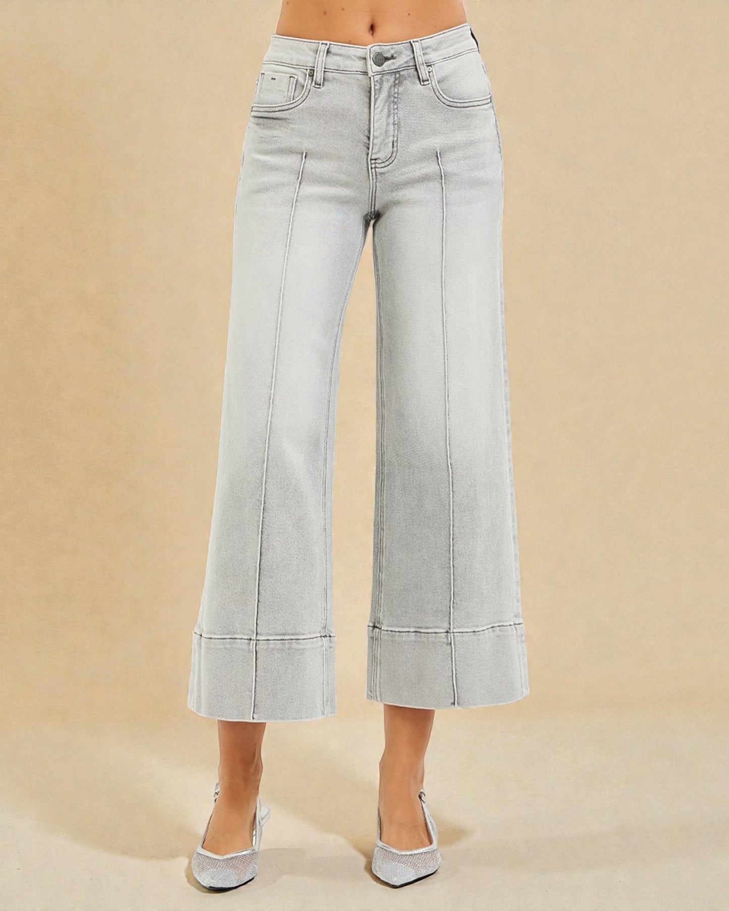 Light blue jeans worn by a person on a beige background