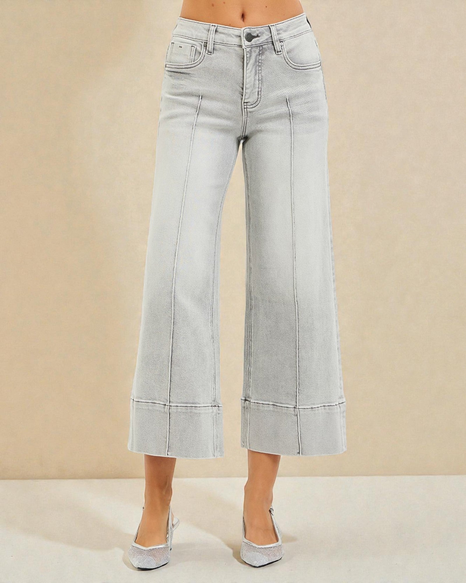 Light blue wide-leg jeans worn by a person on a beige background