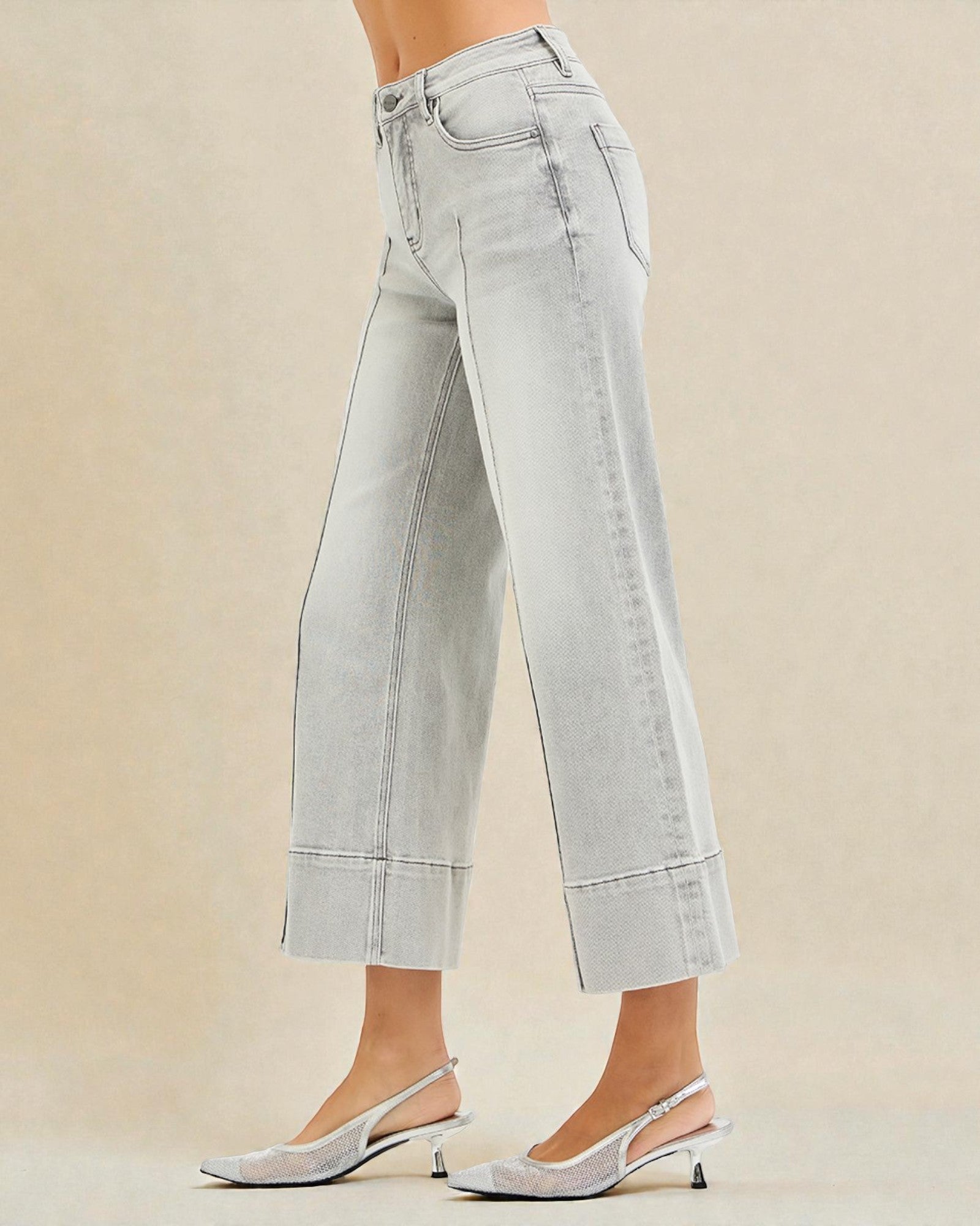 Light gray wide-leg jeans worn by a person on a beige background