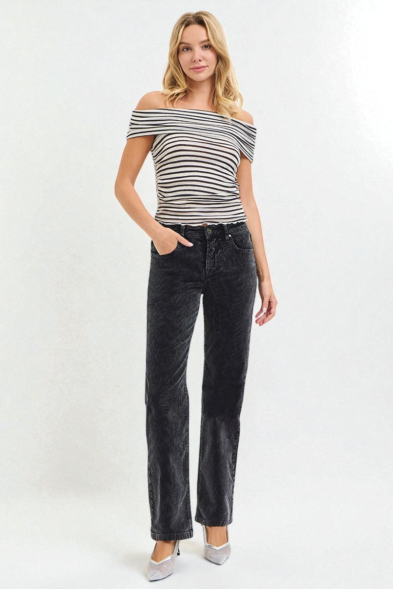 Woman wearing a black and white striped top and black jeans on a white background