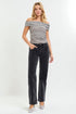 Woman wearing a black and white striped top and black jeans on a white background
