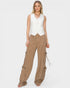 Woman wearing a white sleeveless top and beige cargo pants on a white background