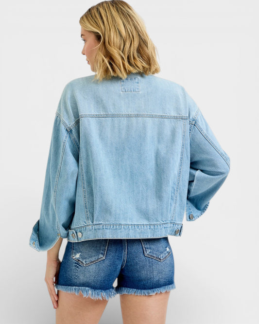 Person wearing a light blue denim jacket and shorts on a white background