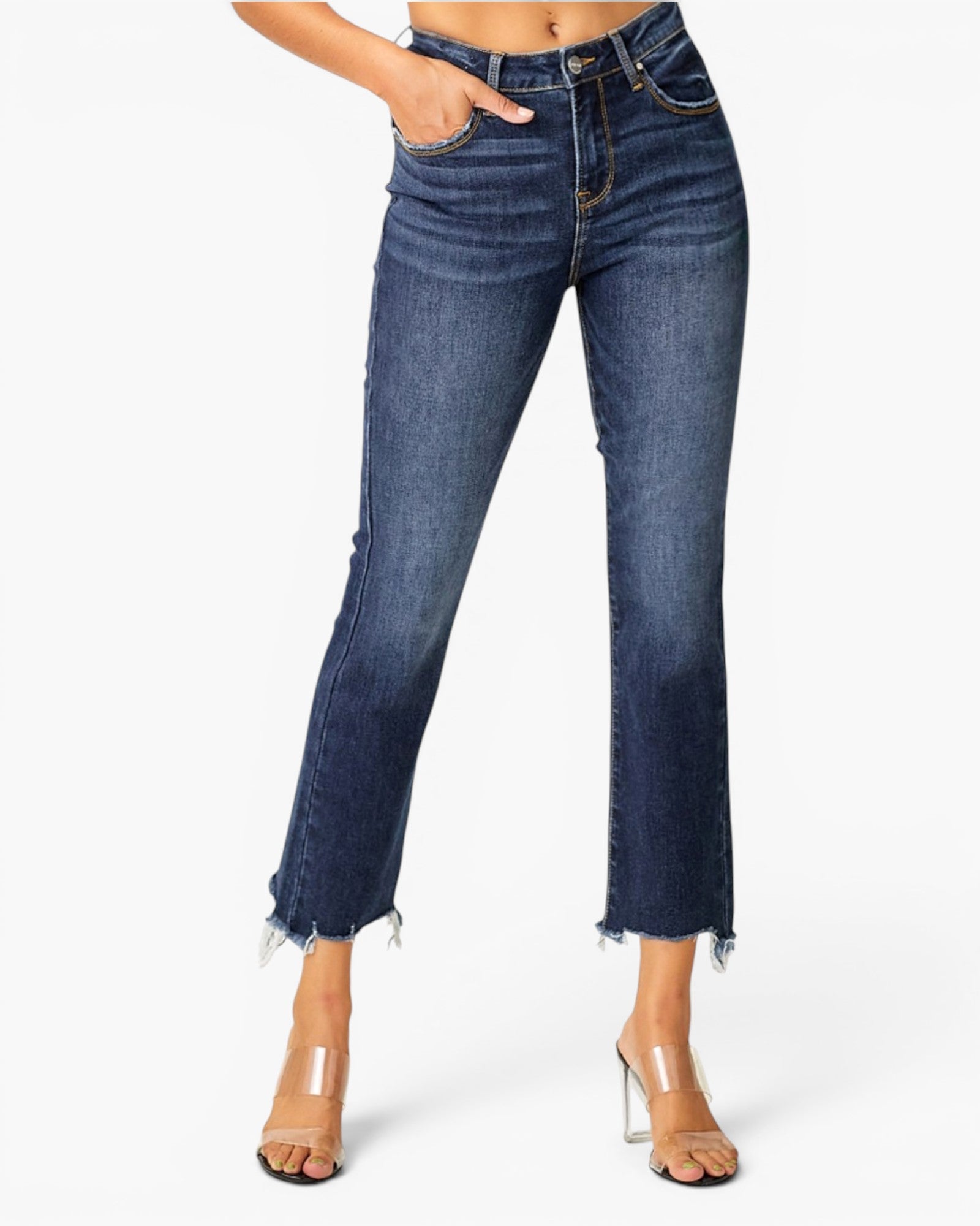 A model wearing dark blue cropped flare jeans with a raw frayed hem and clear high-heeled sandals, shown from the waist down on a light gray background.