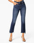 A model wearing dark blue cropped flare jeans with a raw frayed hem and clear high-heeled sandals, shown from the waist down on a light gray background.