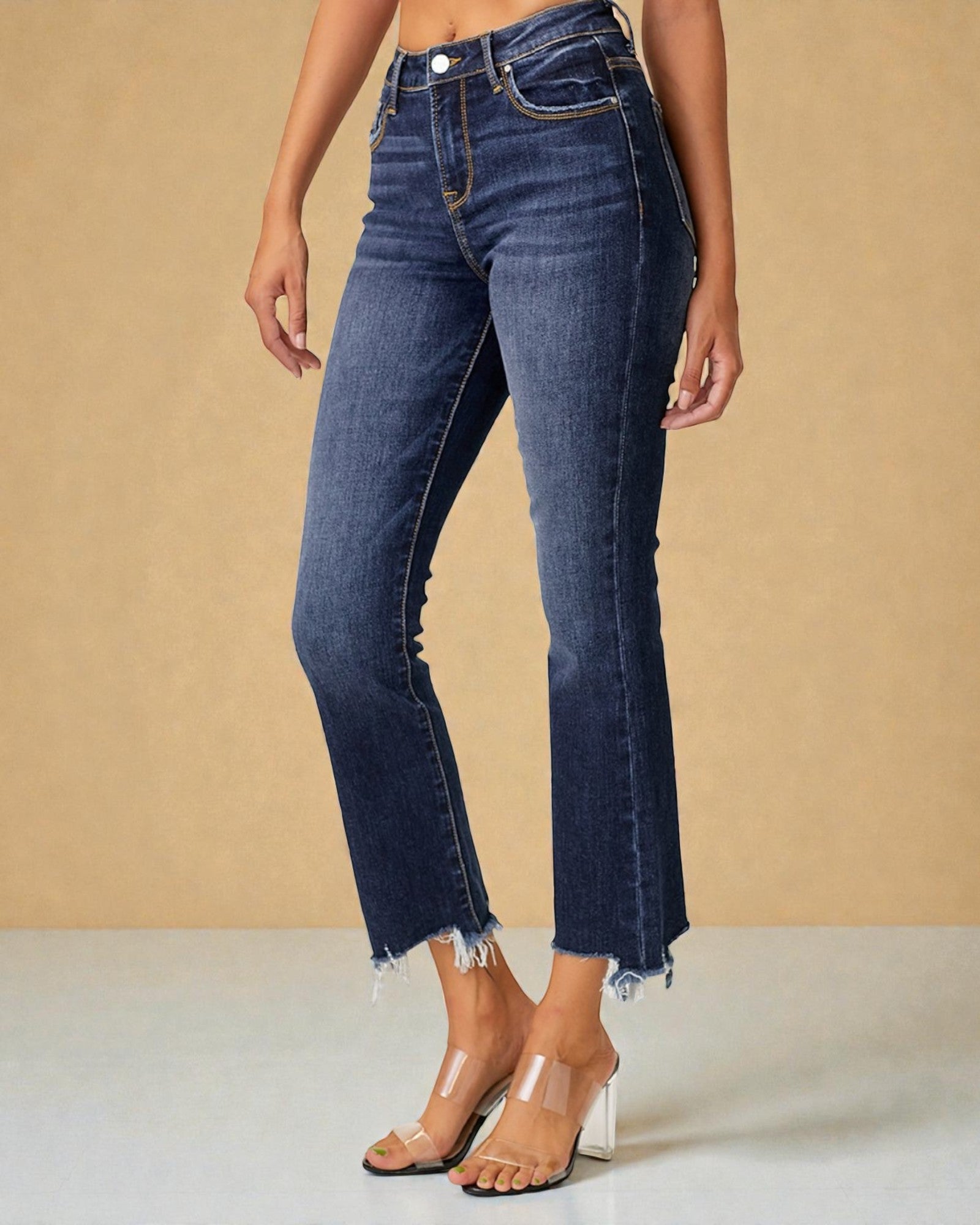 Person wearing blue jeans with a beige background