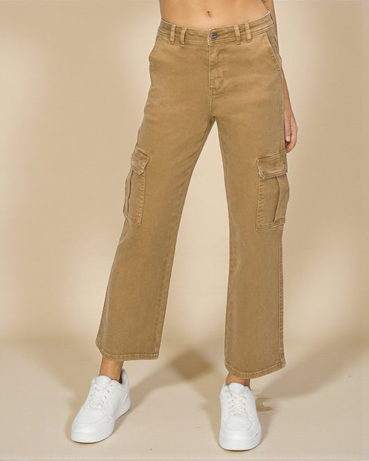 Person wearing tan cargo pants and white sneakers on a beige background