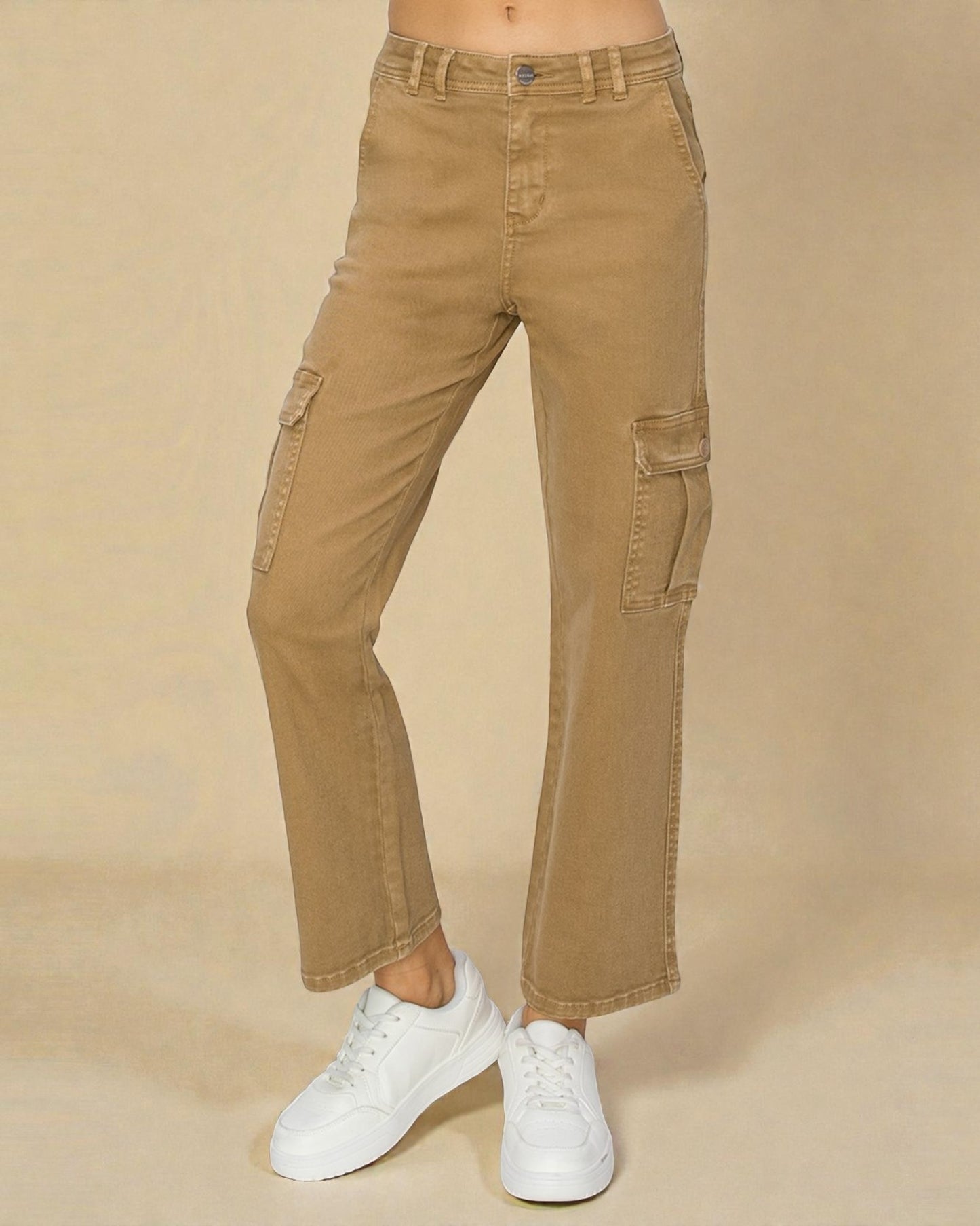 Tan cargo pants worn with white sneakers on a beige background