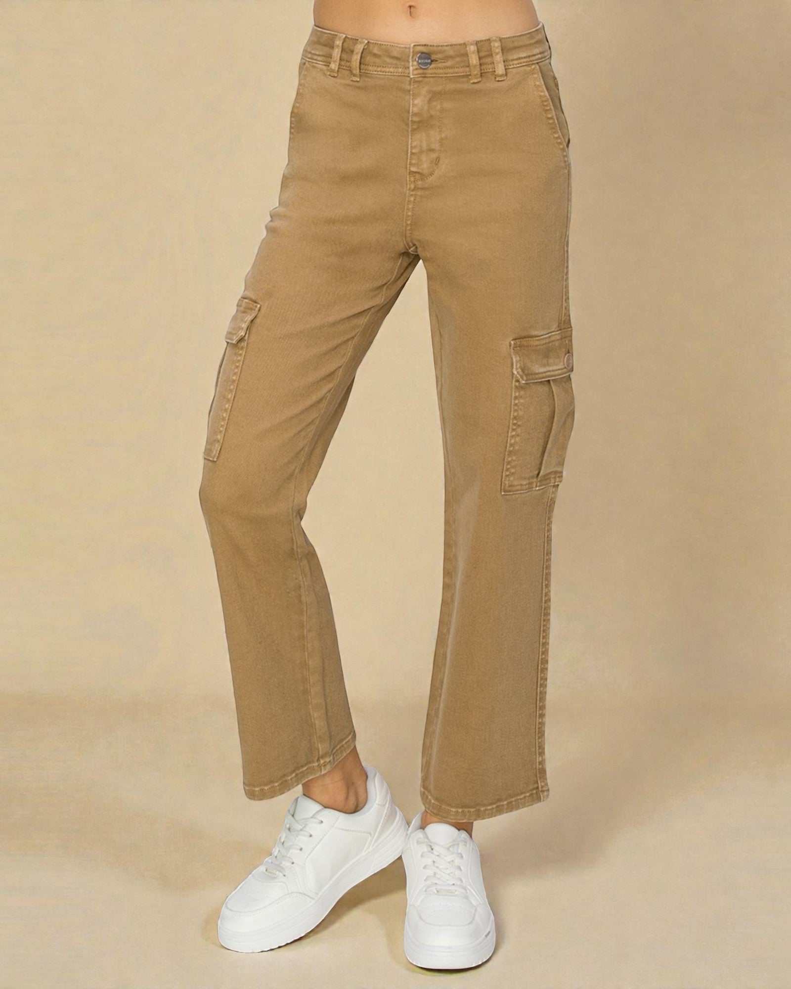 Tan cargo pants worn with white sneakers on a beige background