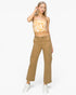 A woman modeling a tan strapless tube top with a white abstract pattern and matching tan cargo pants, paired with white sneakers, against a plain white studio background.