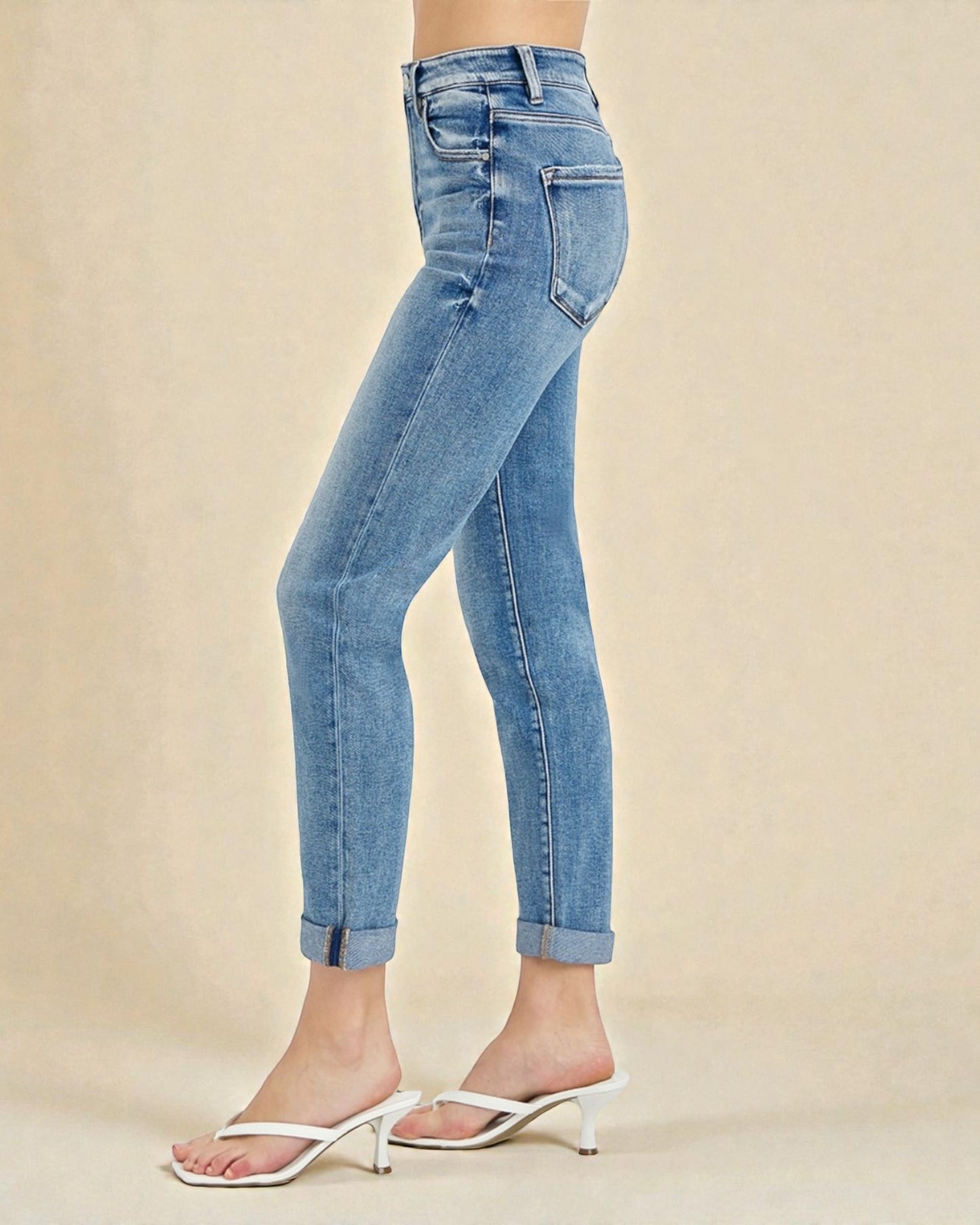 Light blue jeans worn by a person on a beige background