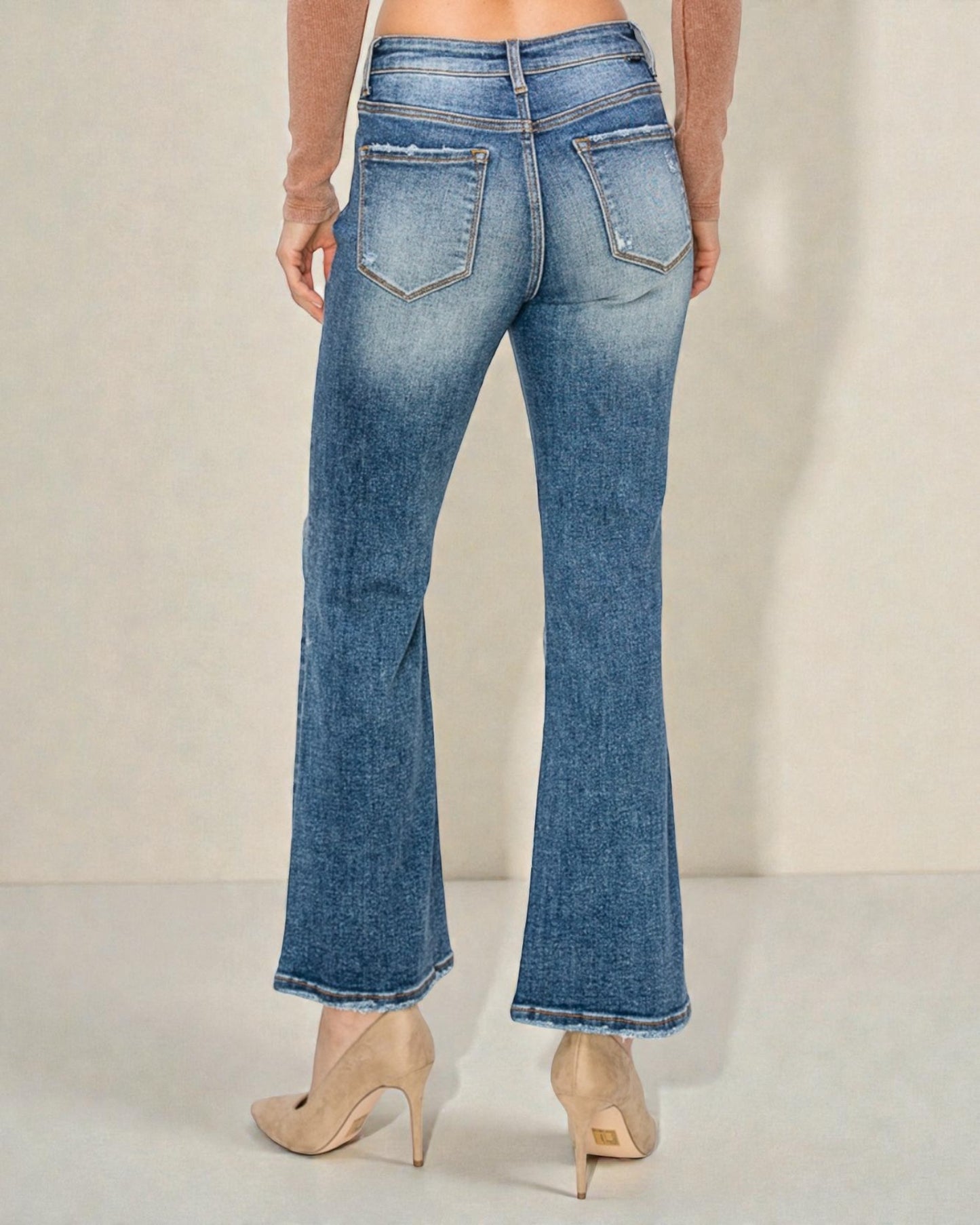 Blue jeans worn by a person on a plain background