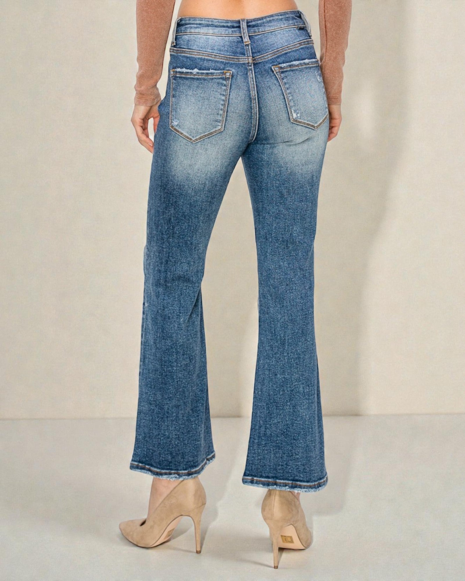 Blue jeans worn by a person on a plain background