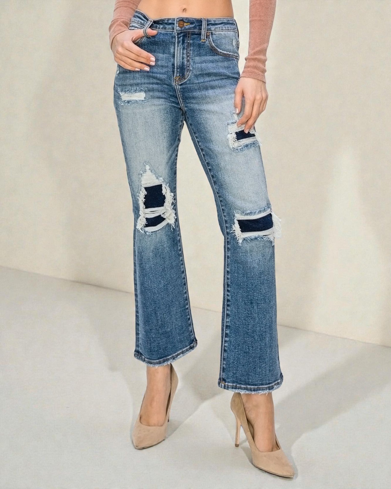 Light blue jeans with distressing details worn by a person on a neutral background