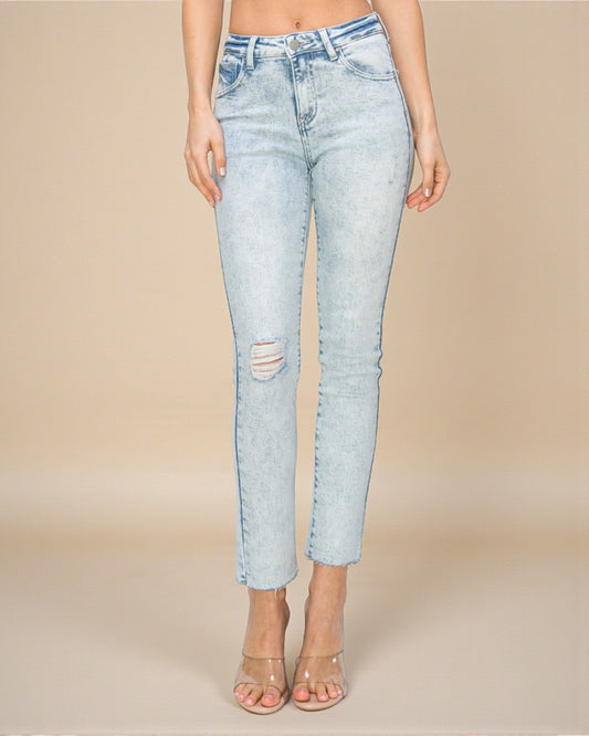 Light blue jeans with a distressed design on a beige background