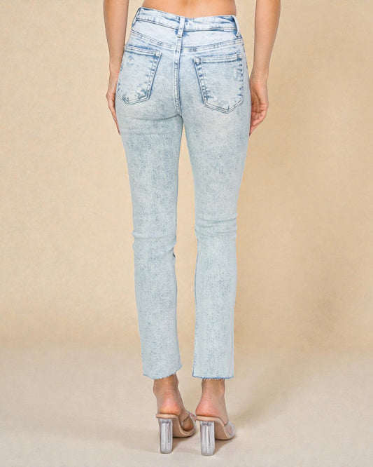 Light blue jeans worn by a person on a beige background