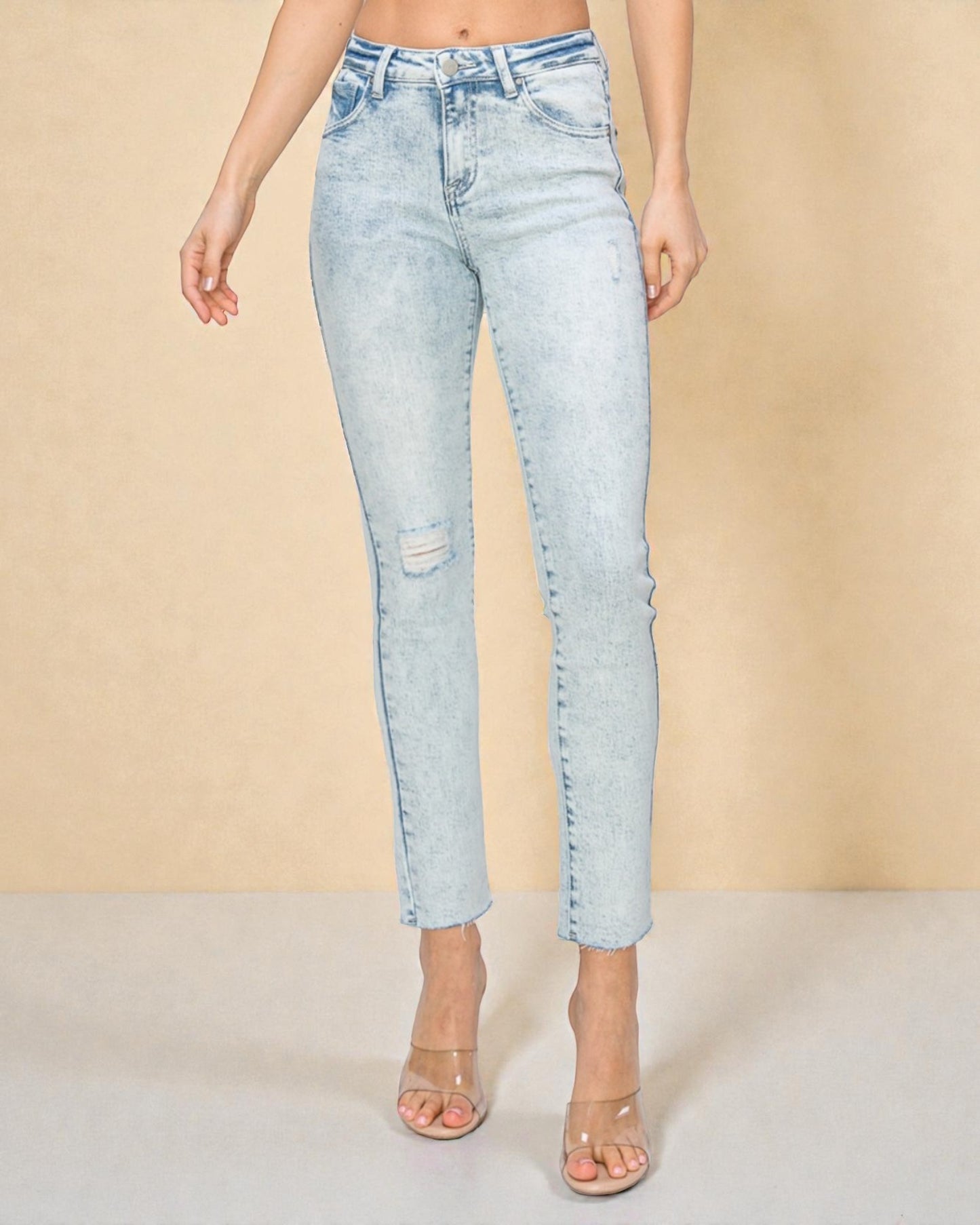 Light blue jeans worn by a person on a beige background