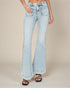 Light blue flared jeans worn by a person on a beige background