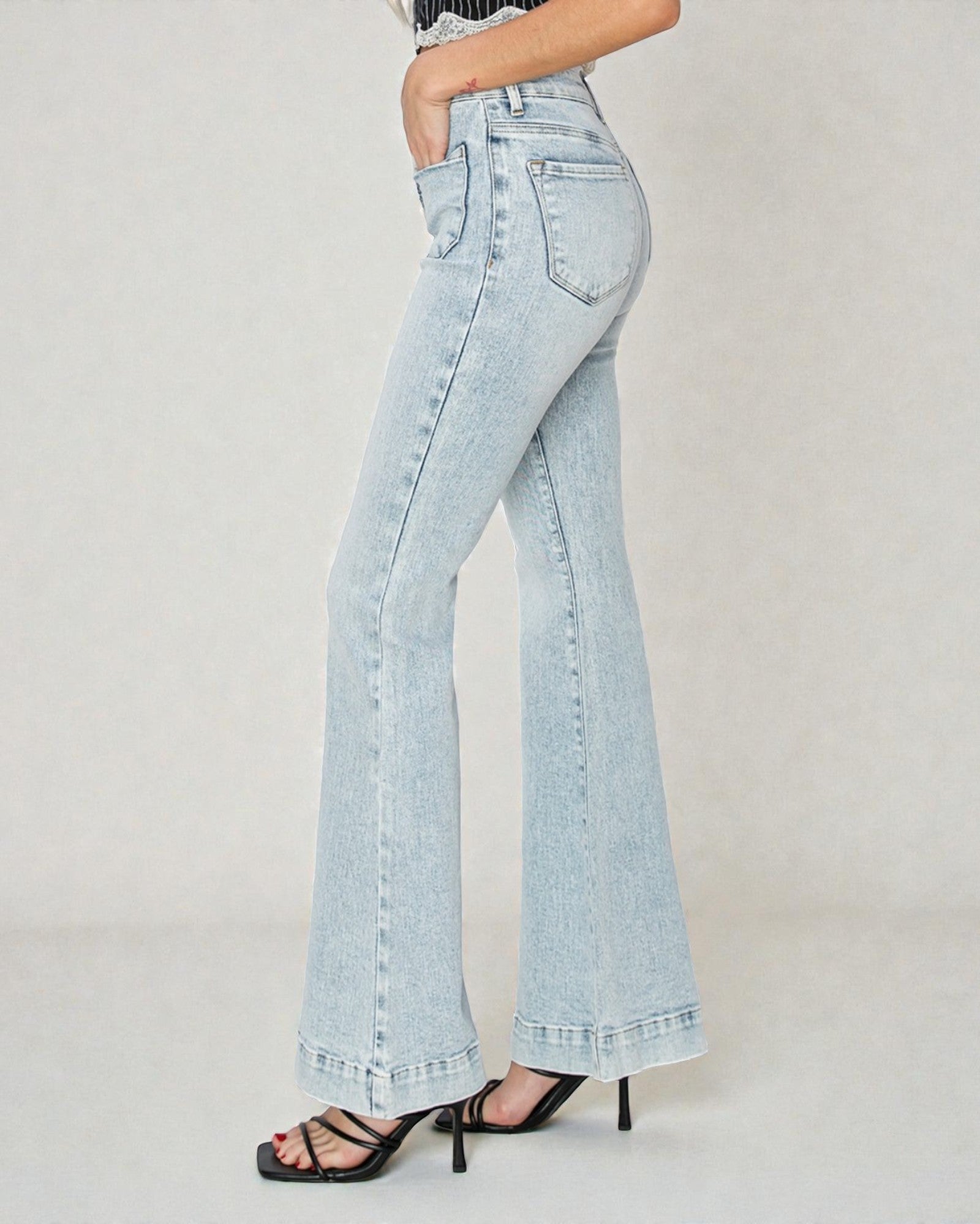 Light blue flared jeans worn by a person on a plain background